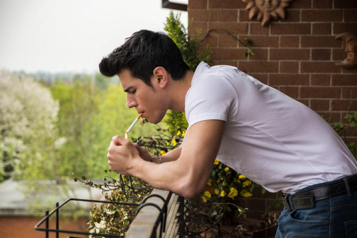 The husband goes out on the balcony to smoke